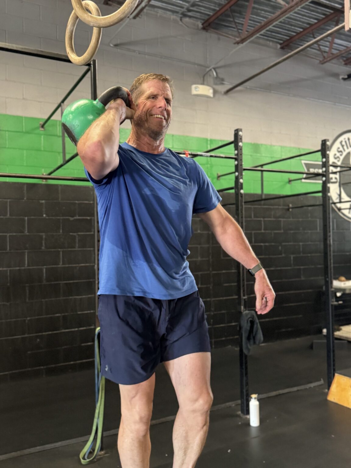 A CrossFit Magnitude member smiling while training with a kettlebell